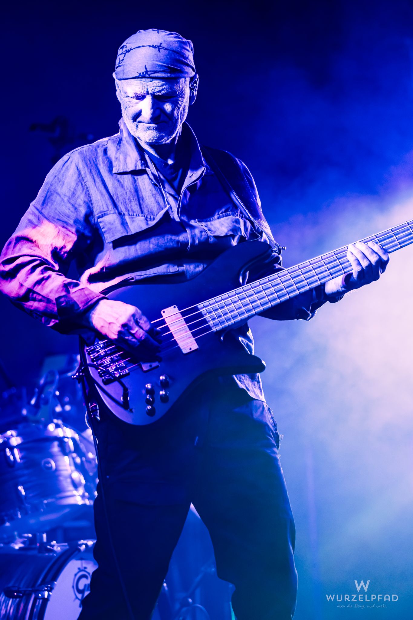 Bassist der Band 'Beyond – A Pink Floyd Tribute' live auf der Bühne. Der Musiker spielt unter dramatischem blauem Licht und liefert eine packende Performance, die die legendäre Musik von Pink Floyd ehrt.